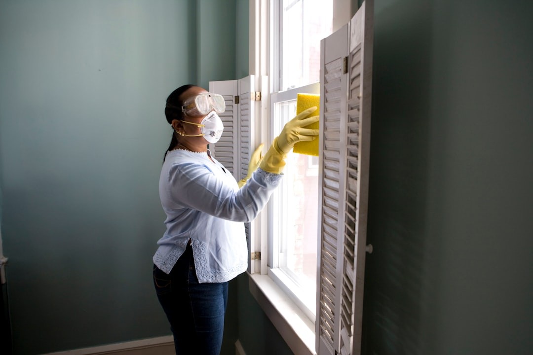 When renovating a home, you should use a damp sponge or cloth to clean dust collected on a window sill, as the dust may contain asbestos or lead-based paint. Home maintenance is an ongoing process for any homeowner, and here we see an African- American woman who’d taken a damp sponge to her window’s frame, in order to remove accumulated dust particulates. Note how the homeowner had donned a pair of waterproof gloves, a facemask, and a pair of goggles, prior to beginning this task.